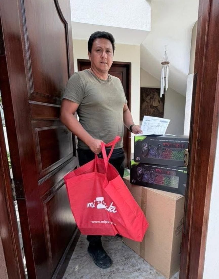 Cliente en la puerta de su casa con la bolsa y las cajas de su PC gamer